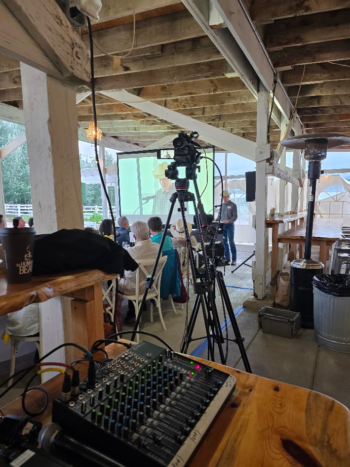 Barn event AV position with PTZ camera on tripod and audio mixer