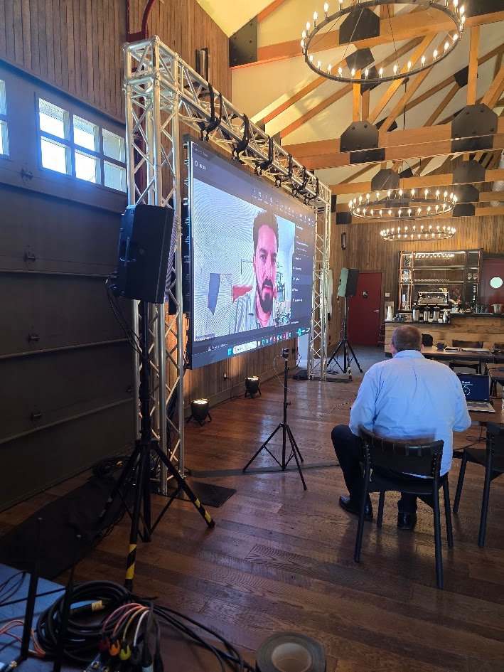 Barn venue LED screen on truss showing video call