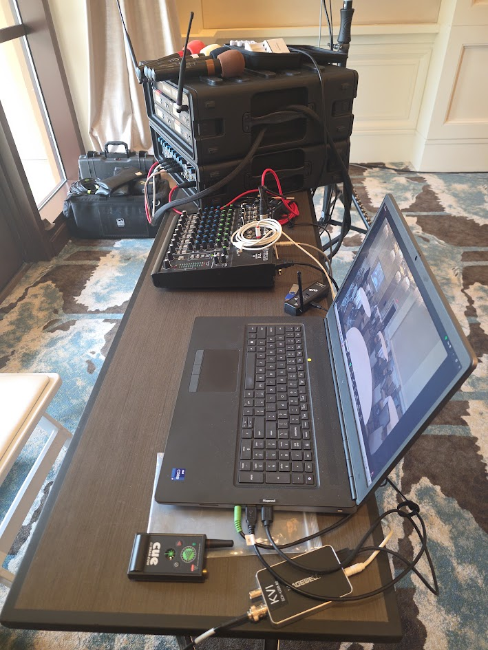 Event tech table with laptop, audio mixer, and wireless mics