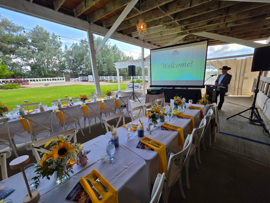 Outdoor pavilion event with welcome screen and decorated tables