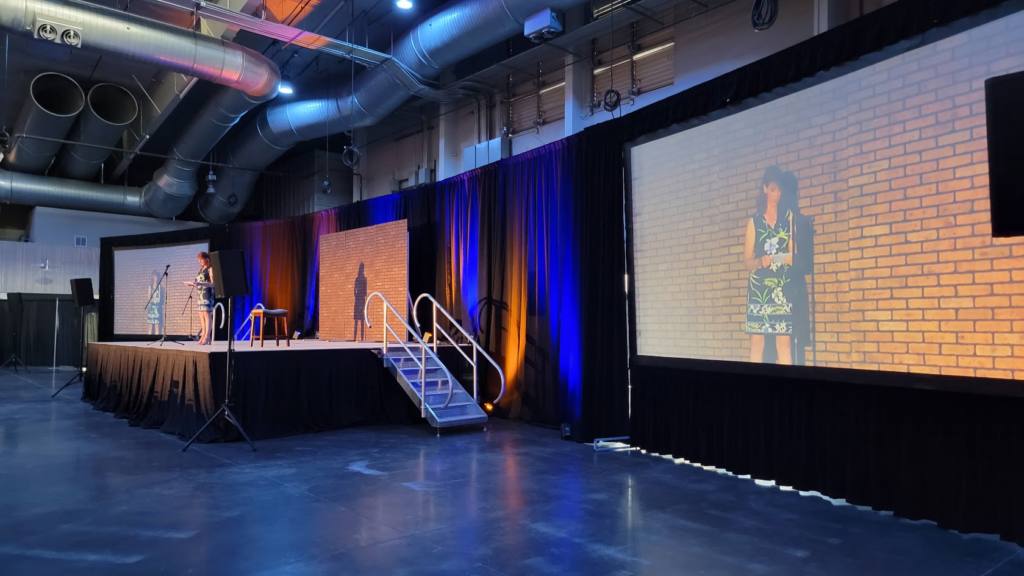 Large corporate stage with IMAG screen and blue uplighting